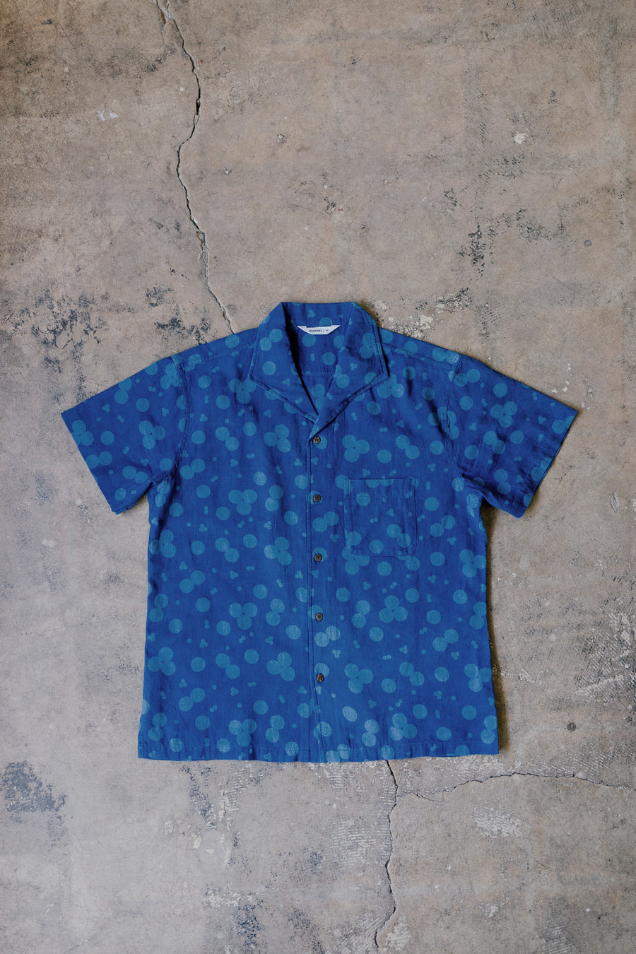 The blue colorway of the shirt has bleached out patterns.