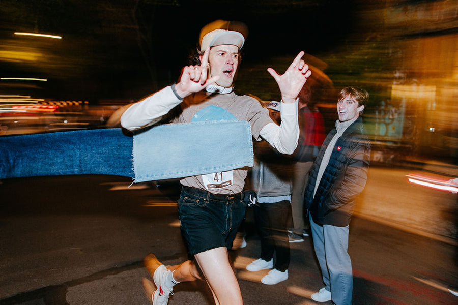 A man crosses the finish line made of jeans.