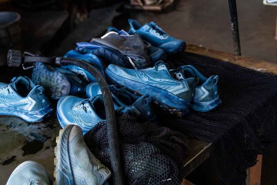 Indigo dyed sneakers dry on a table.