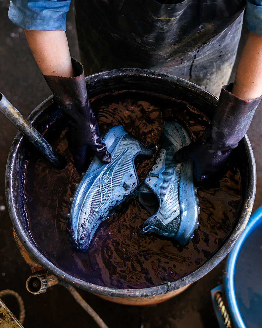 Gloved hands submerge and dye shoes.