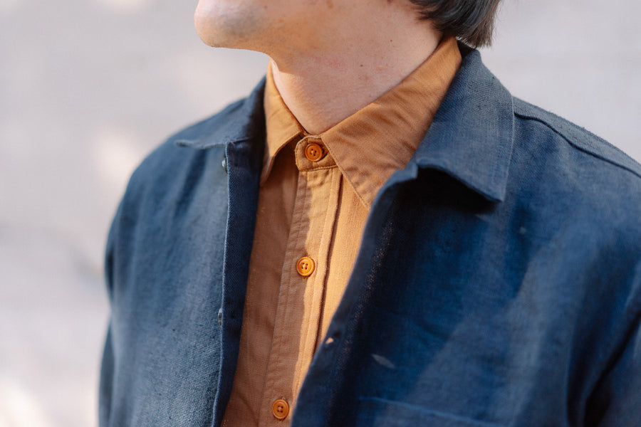 A photo of a navy jacket and sienna button down.