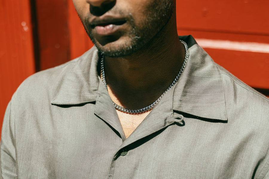 A close up image of a textured olive shirt collar.
