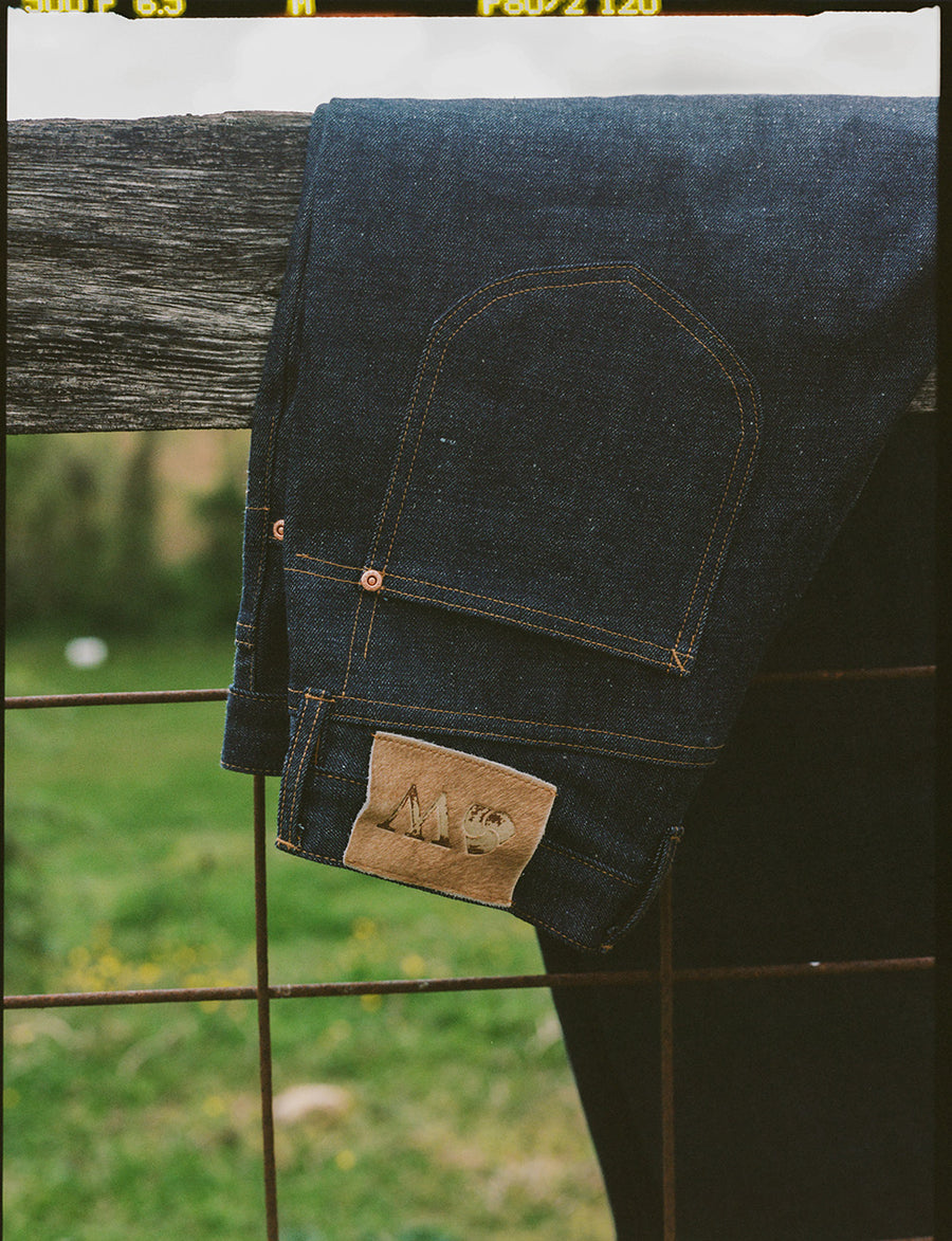 A pair of jeans on a fence.