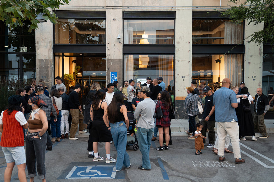 A ton of people hanging out outside a shop.