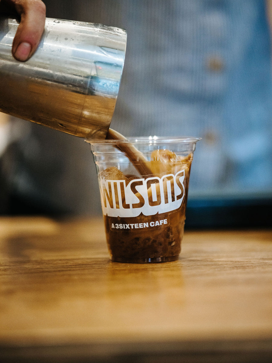 An espresso cocktail poured into a plastic cup with the Wilson's logo on it.