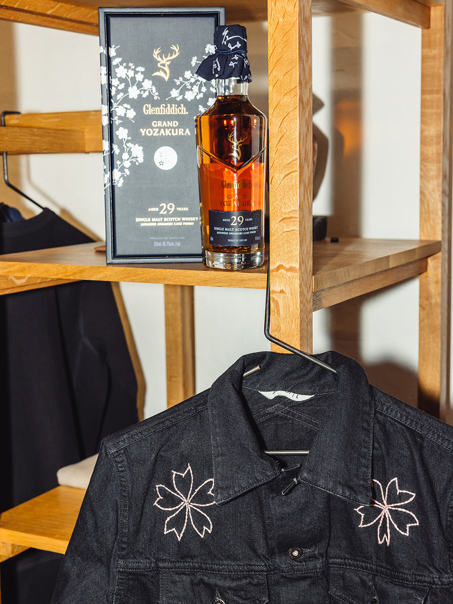A photo of the 29 year old scotch next to a black denim jacket.