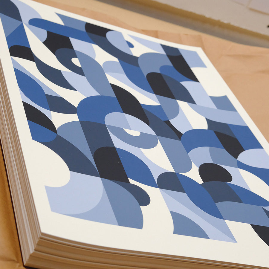 A stack of art prints on a table.