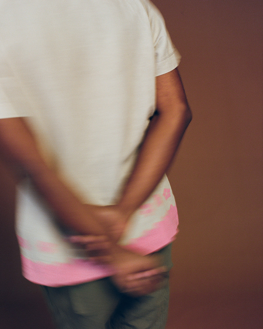 A blurry photo of a shirt with hands crossed behind the back.