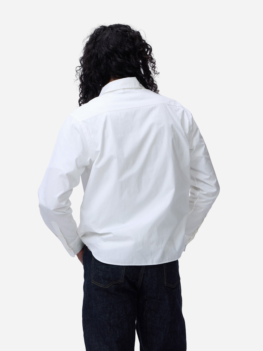 Person wearing a white shirt and dark pants on a white background