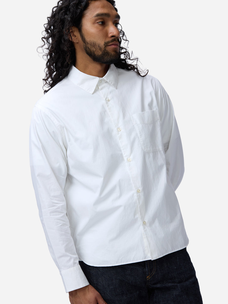 Man wearing a white button-up shirt against a plain background