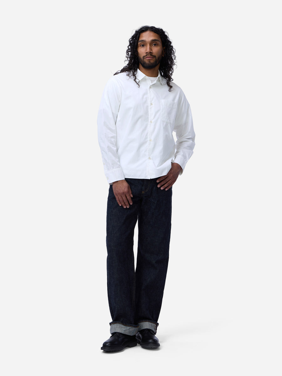 Person wearing a white shirt and dark jeans on a white background