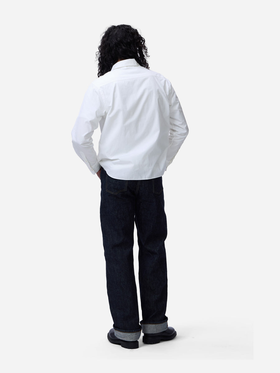 Person wearing a white shirt and dark pants on a white background