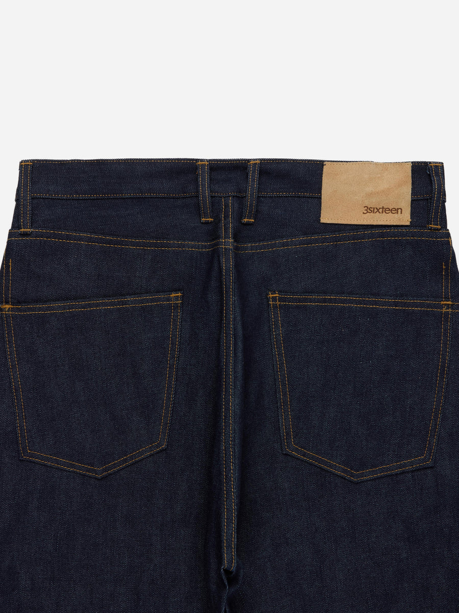 Dark blue jeans with a visible brand label on a white background