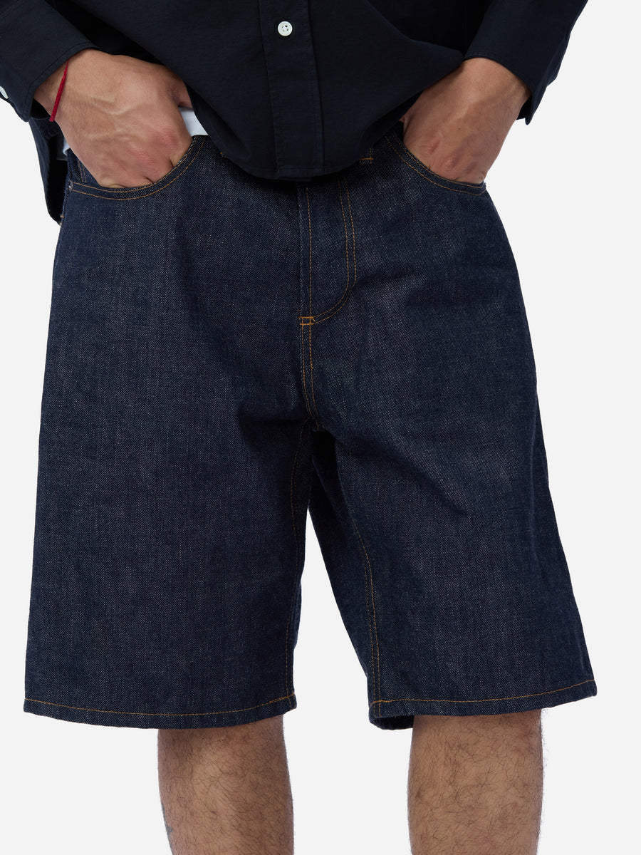 Person wearing dark blue denim shorts on a white background