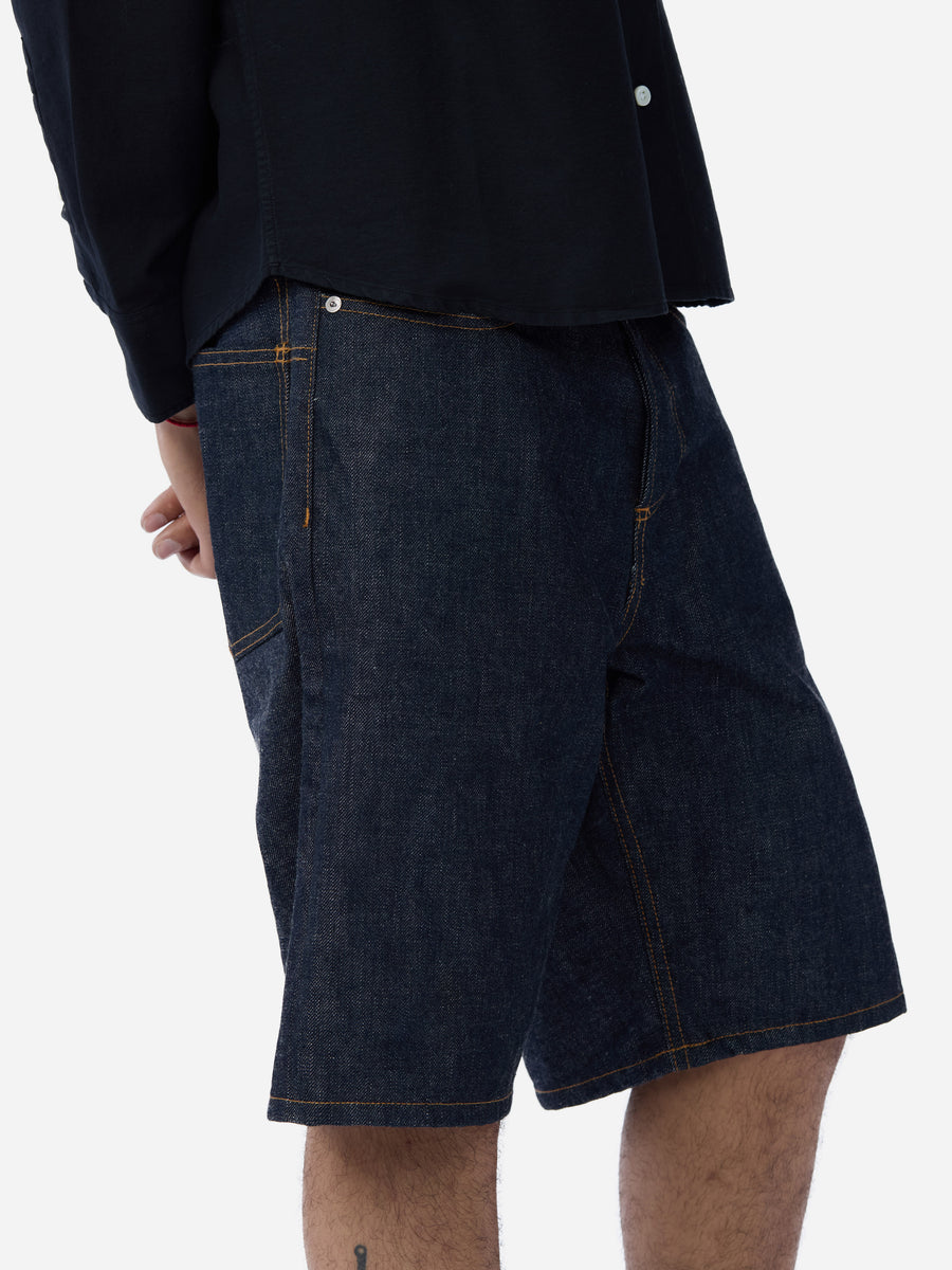 Dark blue denim shorts worn by a person on a white background