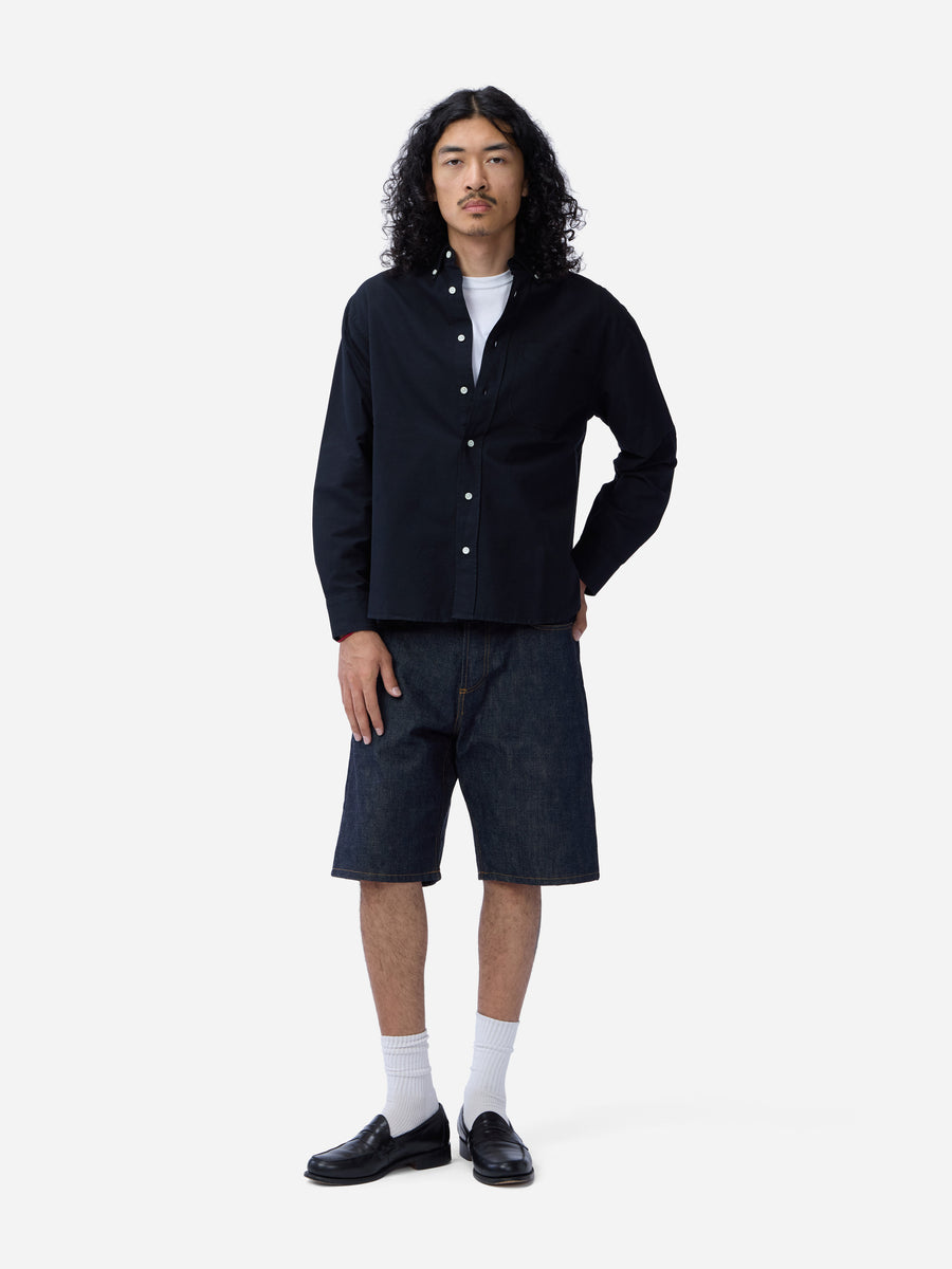 Man wearing a black shirt and shorts on a white background