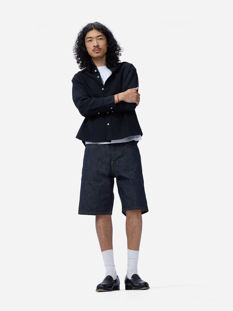 Person wearing a black shirt and shorts on a white background