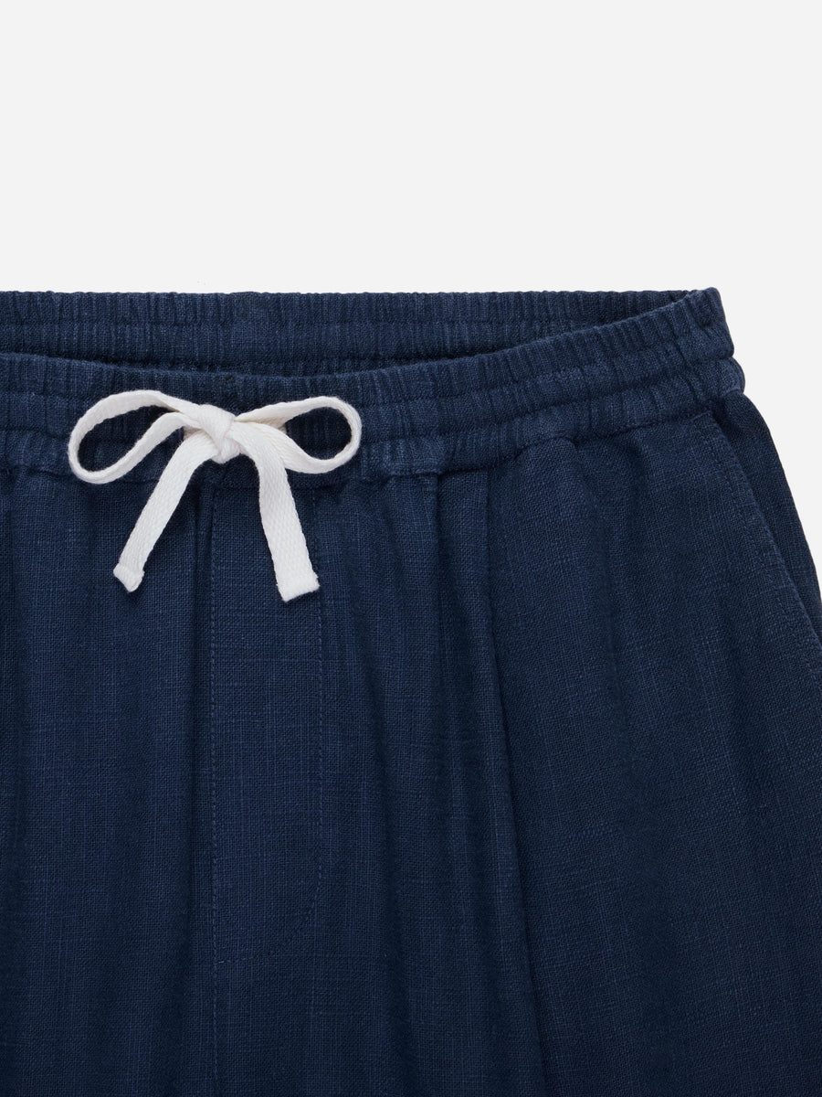 Navy blue pants with a white drawstring on a light gray background