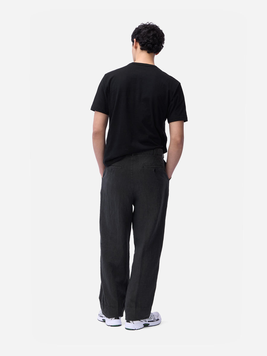 Person wearing a black t-shirt and pants on a white background