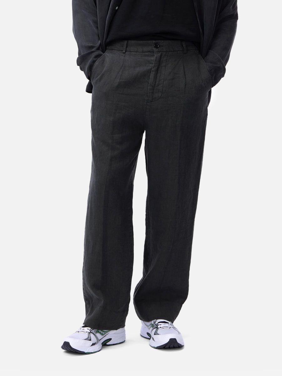 Person wearing black pants and white sneakers on a white background