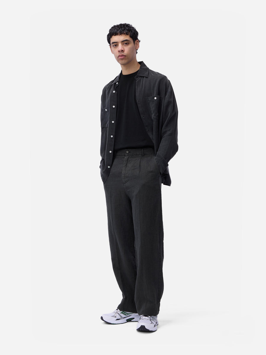 Man wearing a black jacket and pants on a white background