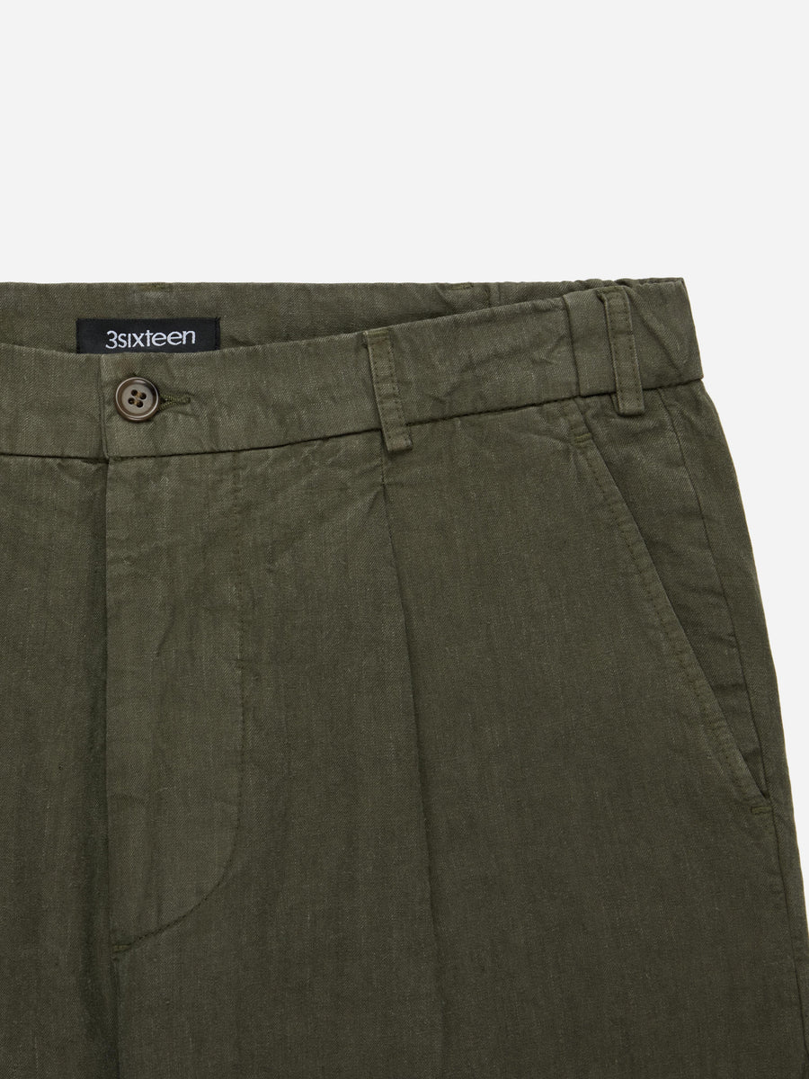 Close-up of green pants with a visible brand label on a white background