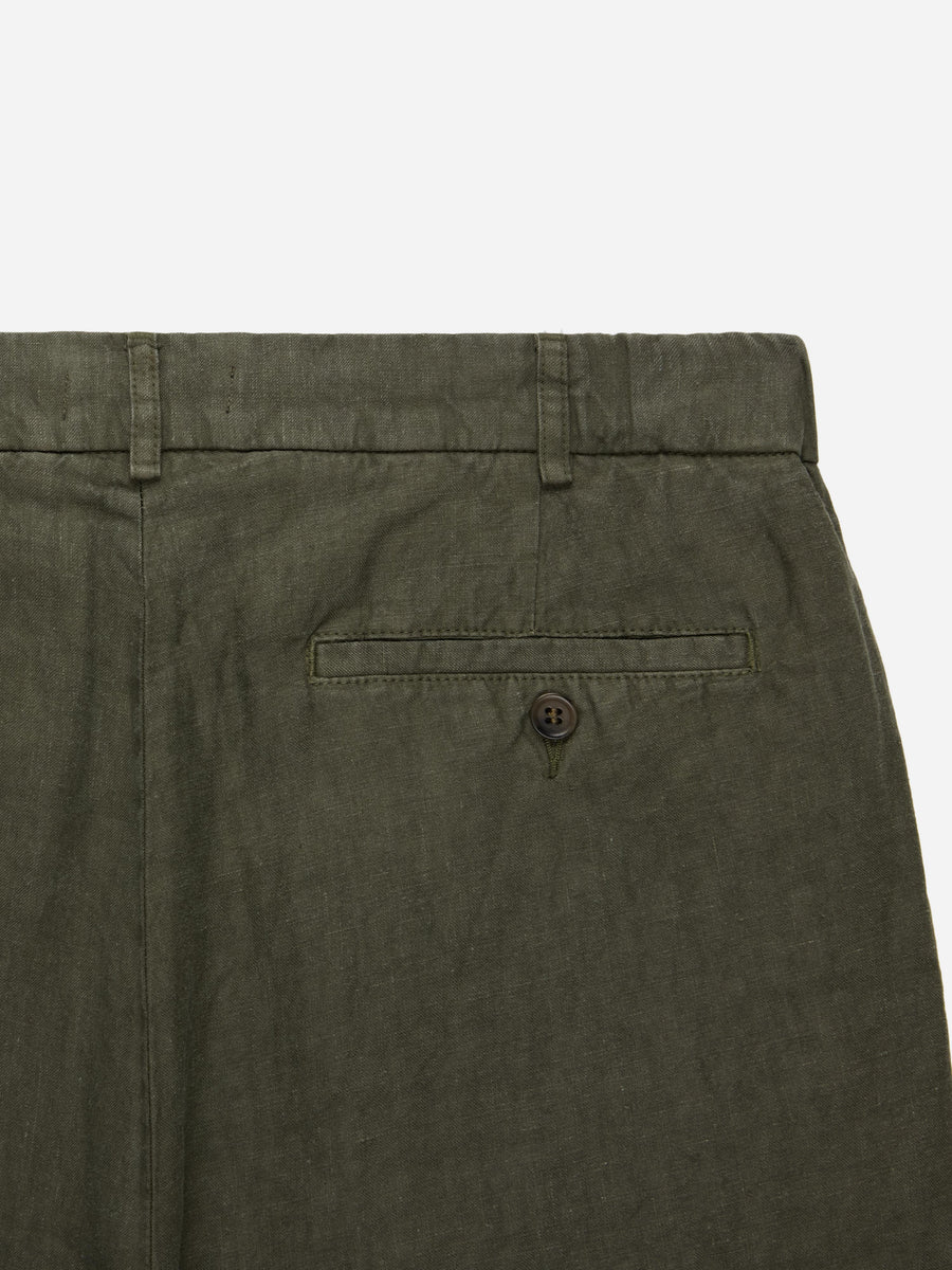 Close-up of olive green pants with a pocket and button on a white background