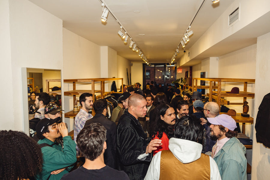 A large group of people sample Glenfiddich 29 year old scotch in a room.