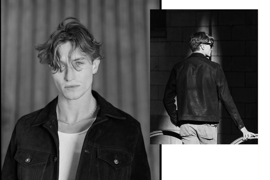 A portrait of a handsome man in a black leather trucker jacket.