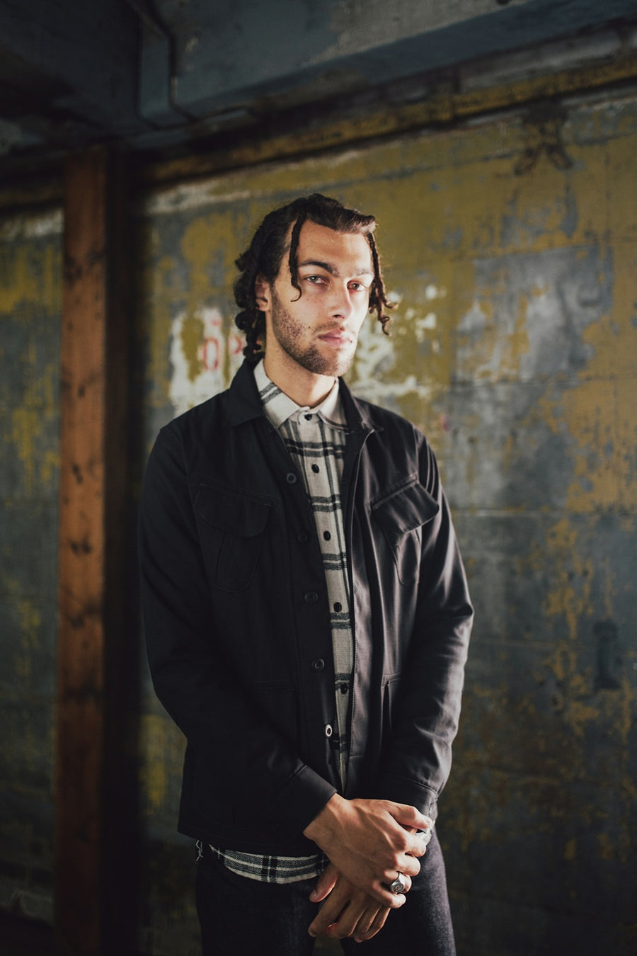 Man wearing jacket and plaid shirt.