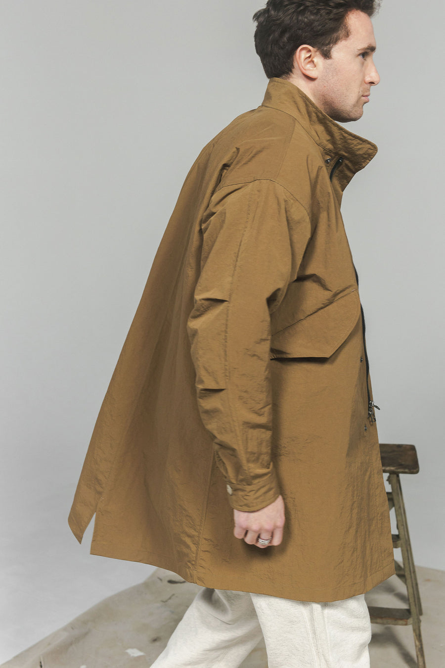 A man in a nylon jacket walks by the camera.