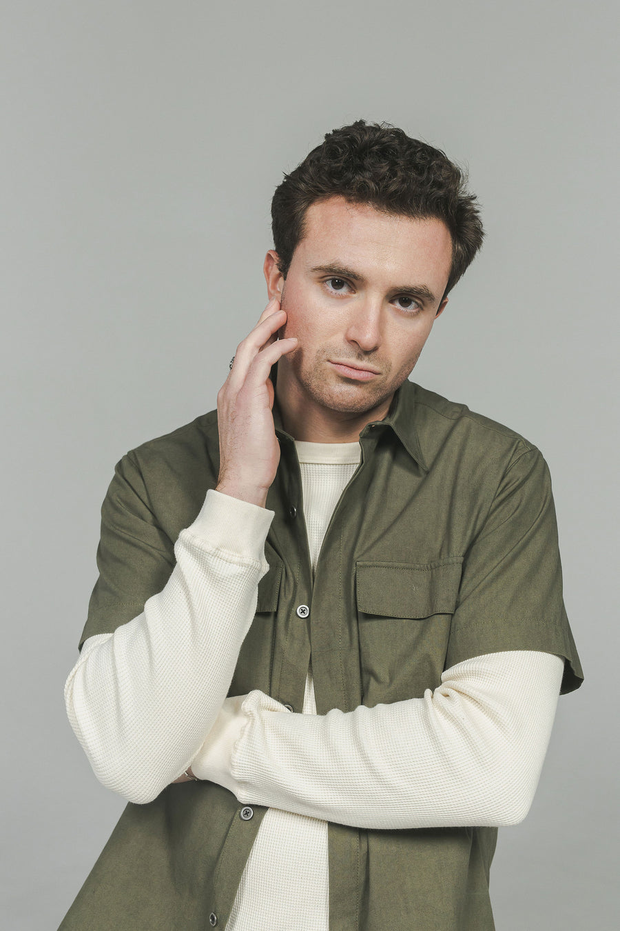 A portrait of a man in a green shirt over a cream thermal.