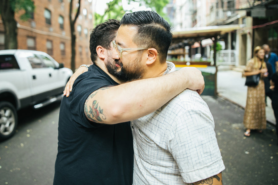 Two men hug.