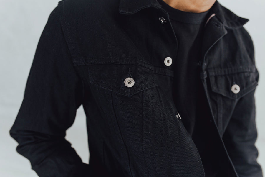 Closeup shot of a man wearing a black 3sixteen Type 3s jacket with a black tshirt underneath