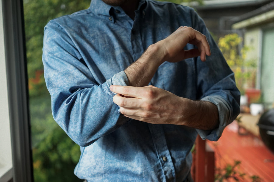 A man adjusts the cuffs of his 3sixteen BD Shirt in Blue Haze.