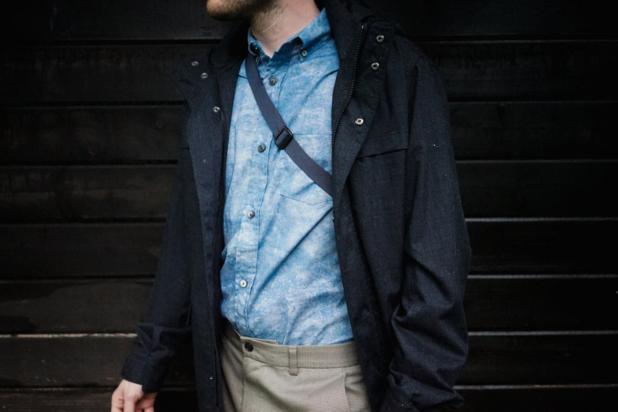 A closeup of the 3sixteen BD Shirt in Blue Haze with a nylon cross-body bag strap over it.