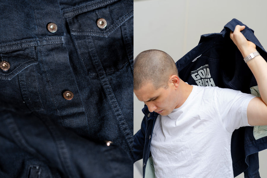 A man puts a denim jacket on.