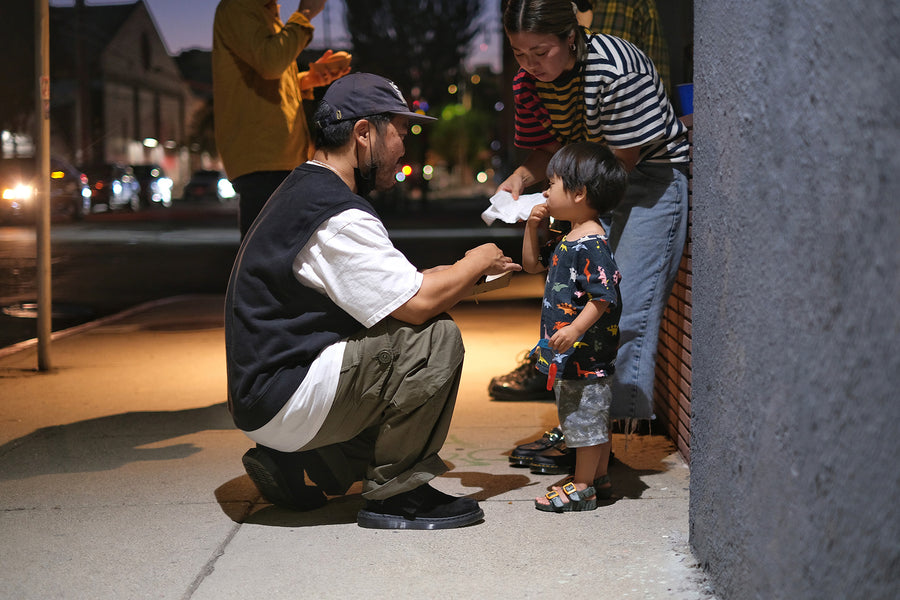 A father feeds his child a burger.