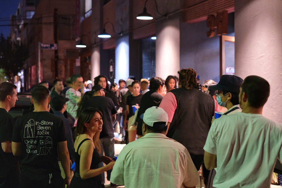 A sea of people outside at night on a sidewalk.