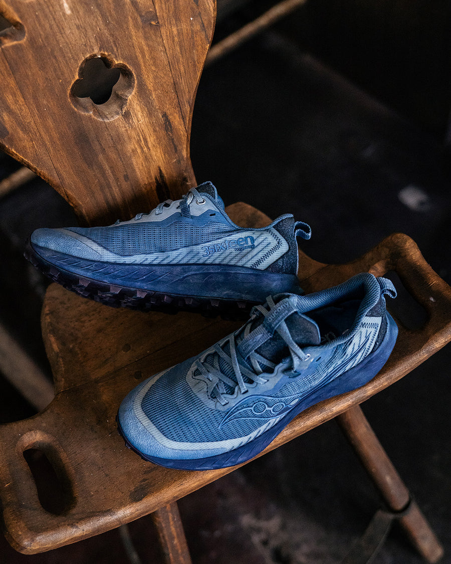 A pair of blue dyed shoes on a wooden chair.