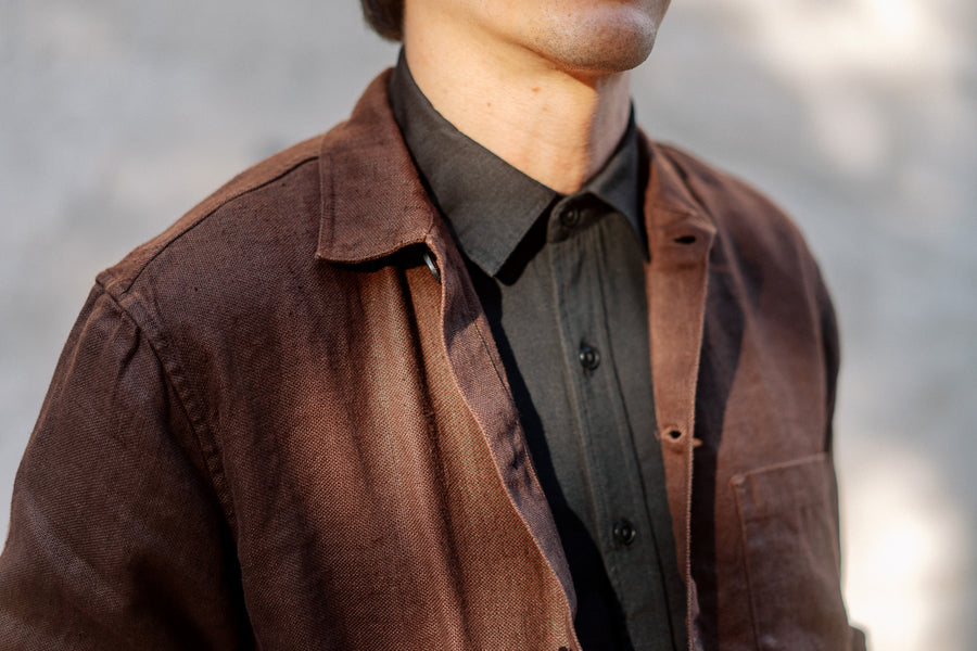 A phot of a textured brown jacket over a black shirt.