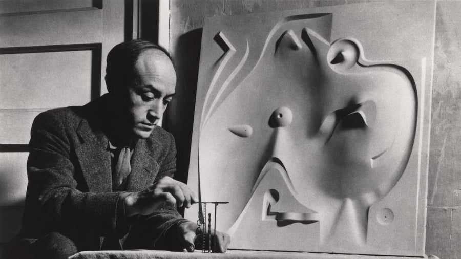 A portrait of Isamu Noguchi working on playground designs. 