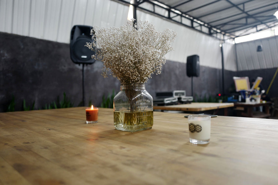 A photo of a table arrangement with dried flowers and candles at the Good Art backyard space