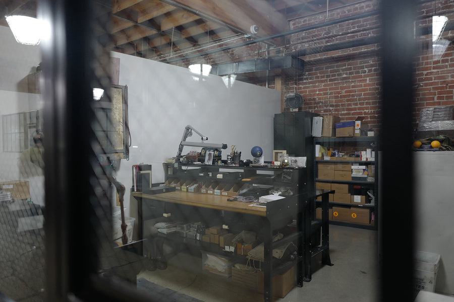 A workbench at the Good Art foundry sits within view through a window on an armored door.
