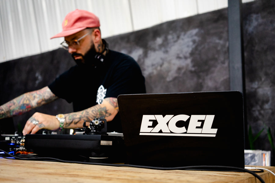 DJ Excel skillfully mixes tracks on the turntables.