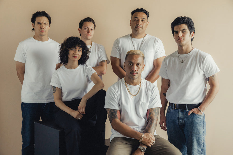 A photo of 6 men and women in white tees against a beige background.